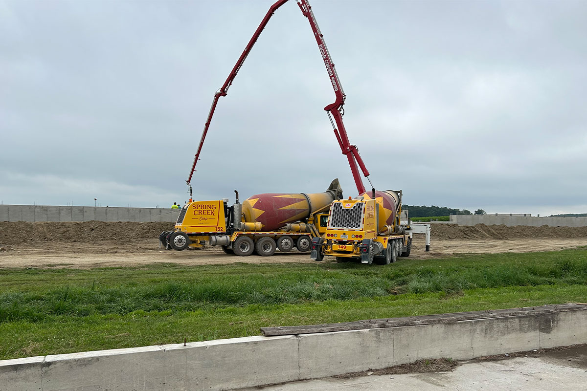 A Spring Creek cement truck at a worksite during the day. 